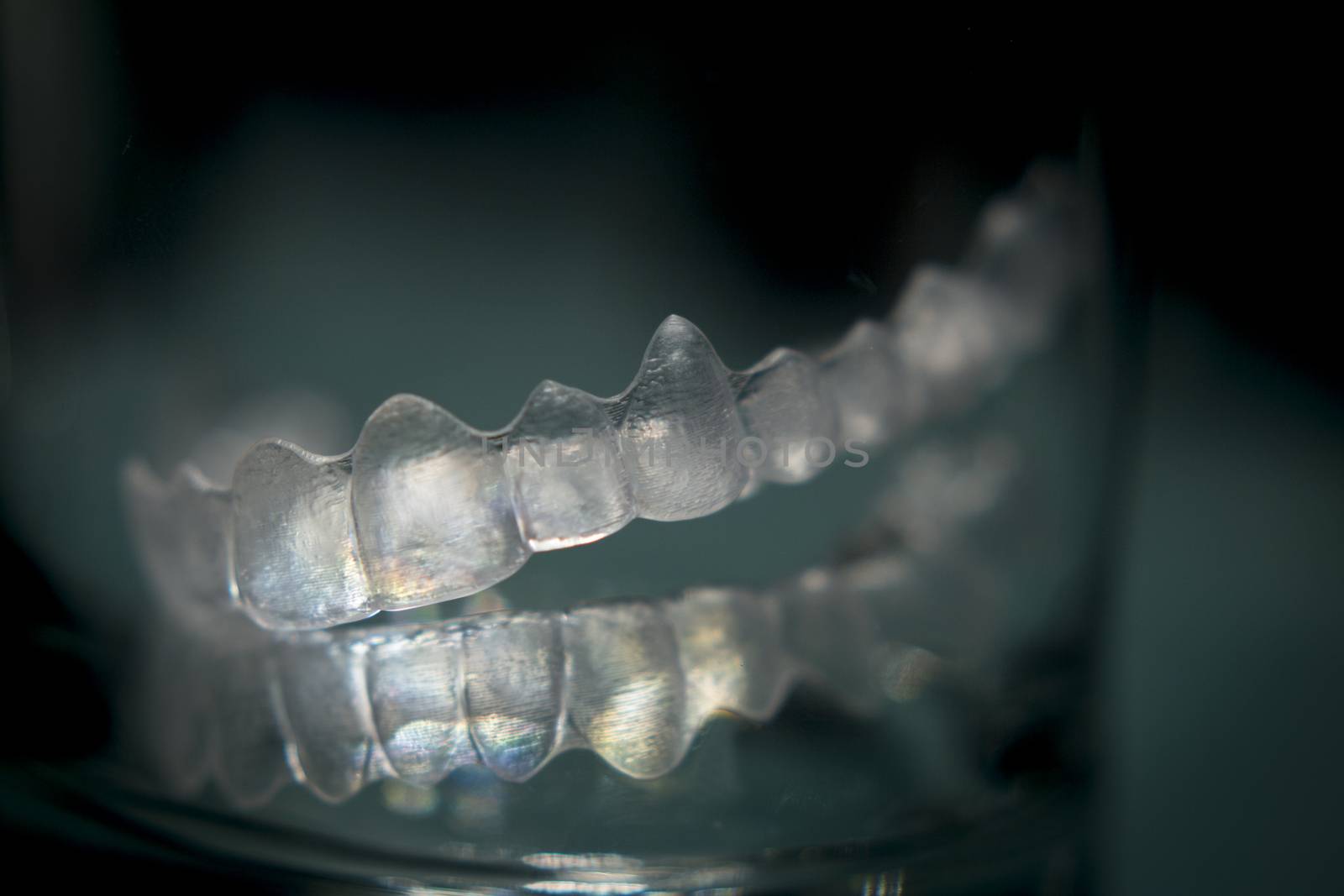 Invisible Invisalign plastic dental teeth brackets tooth braces isolated with shallow depth of focus artistic photograph.