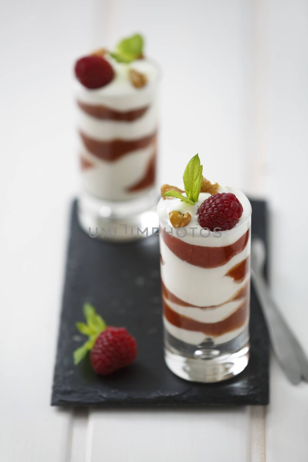 Delicious parfait yogurt dessert with walnuts and raspberries.