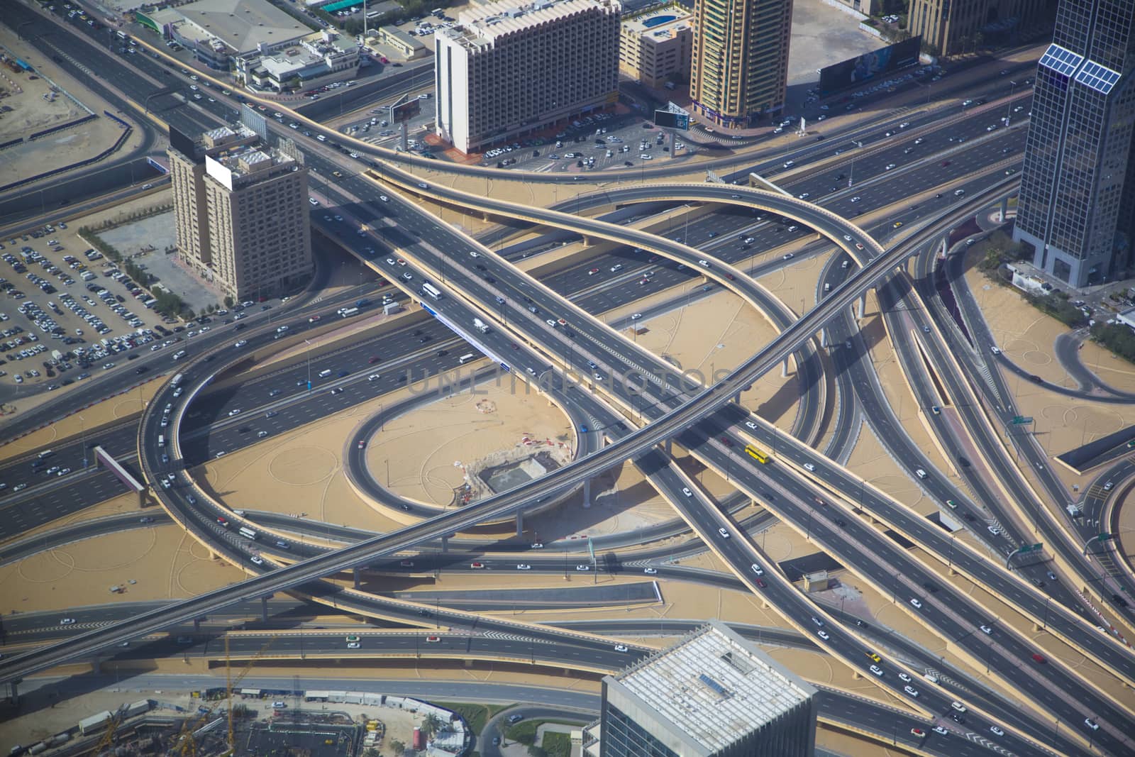 Aerial view of a complex highway overpass in Dubai, UAE. Modern busy city, downtown during the day. Hight contrast color.