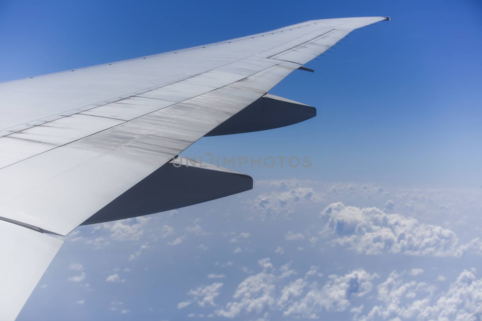 Right Wing of an Aircraft with Rear Engine and Blue Sky at Backg by Nemida