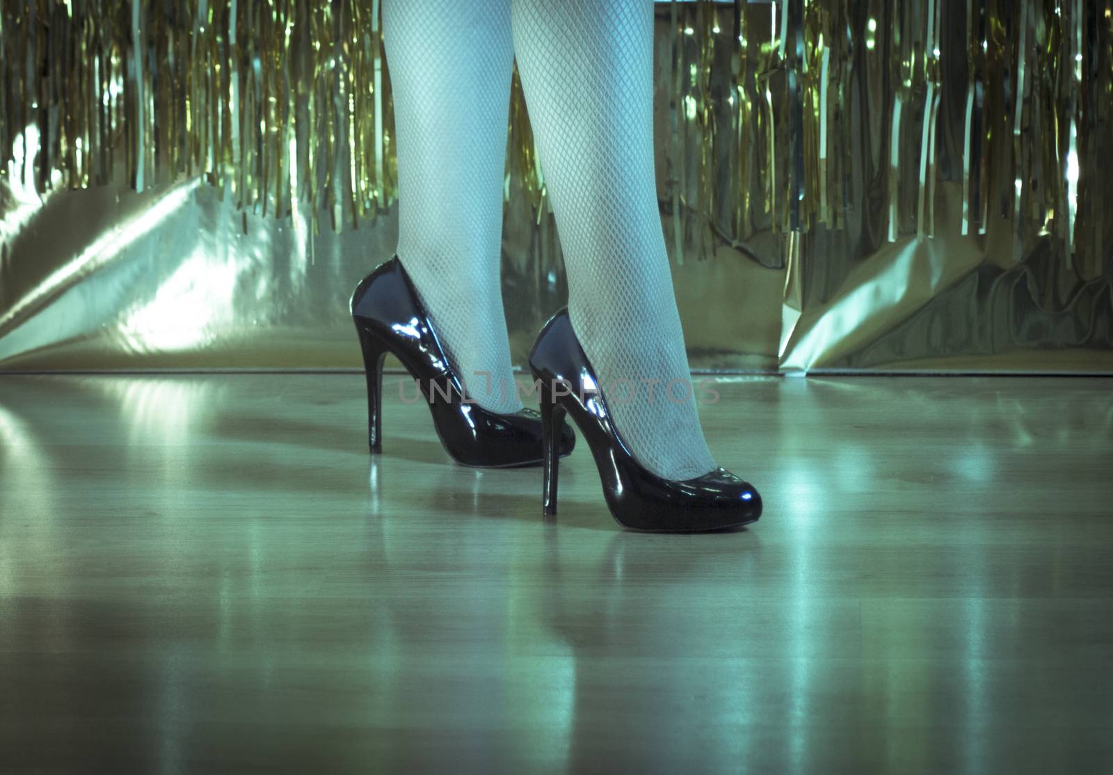 Woman in black high-heeled patent leather shoes