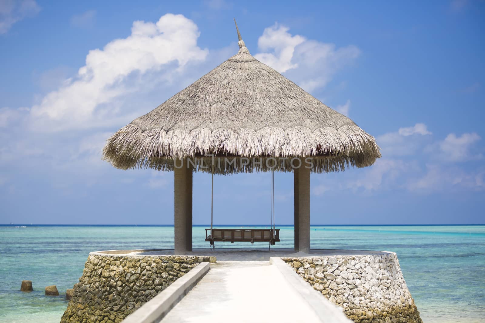 Swing under a tropical beach in Maldives. The hammock is placed to see the sea.