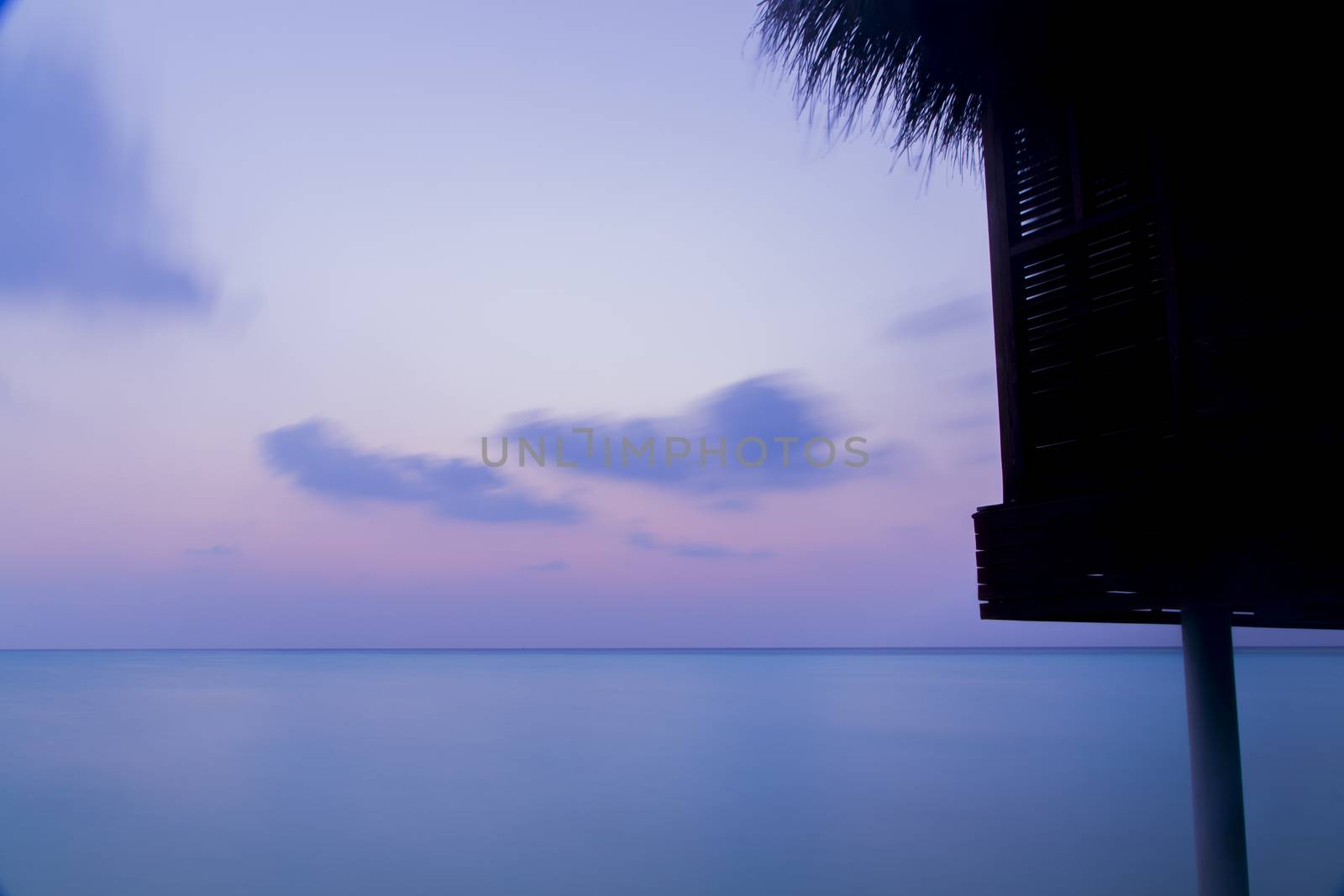 Beautiful tranquil scene of sea in Maldives with a bungalow.