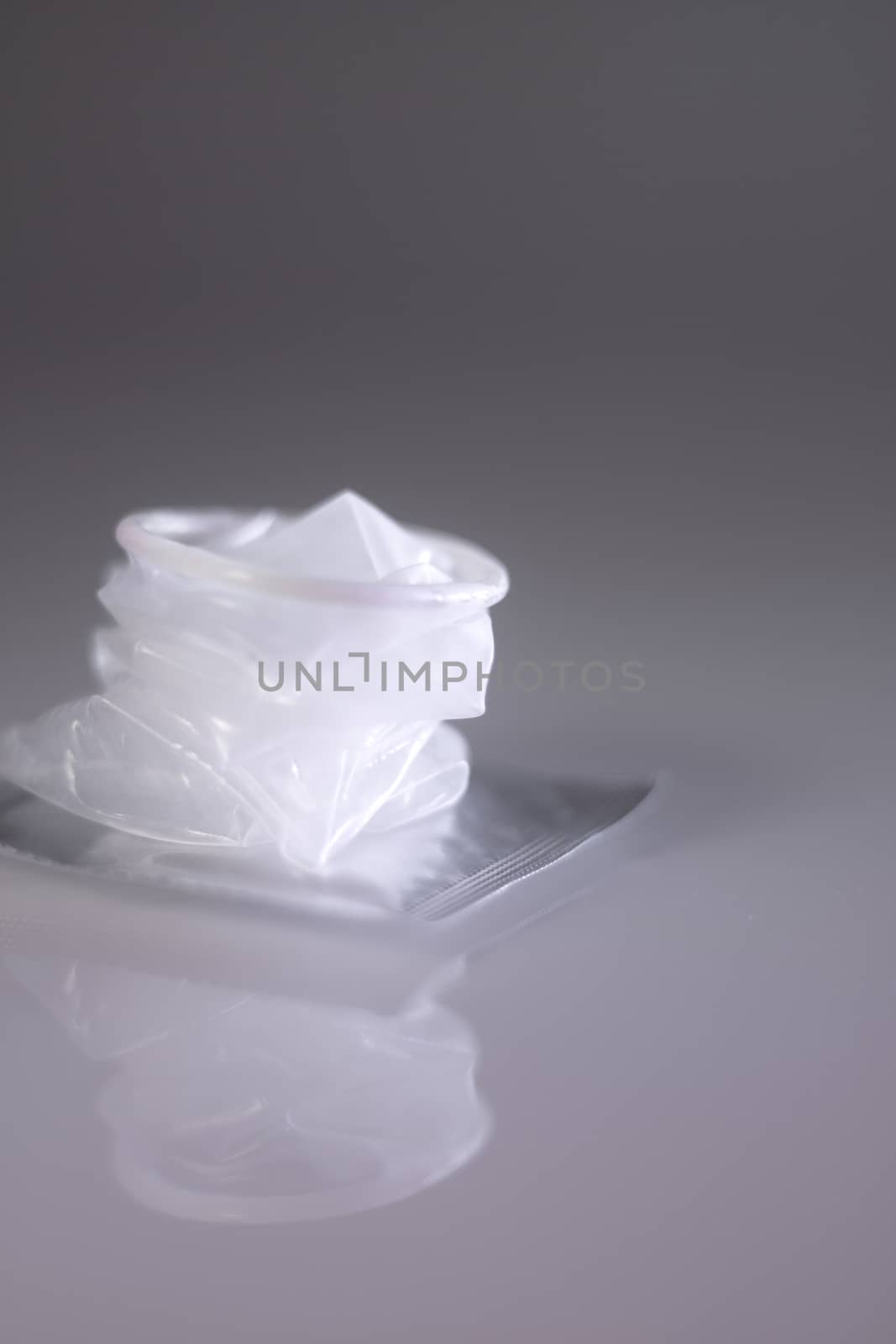 Transparent condom with open pack isolated 