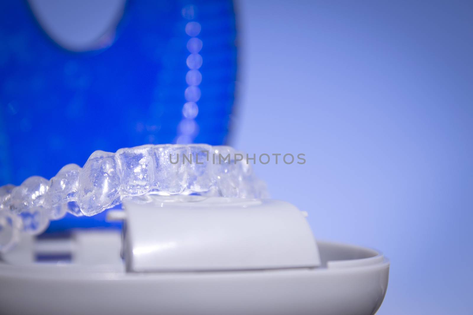 Invisible dental orthodontics in protective case on blue background
