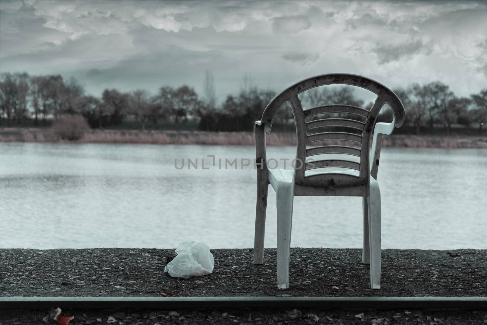 Abandoned chair in an old rail way in the river, atmosphere added.