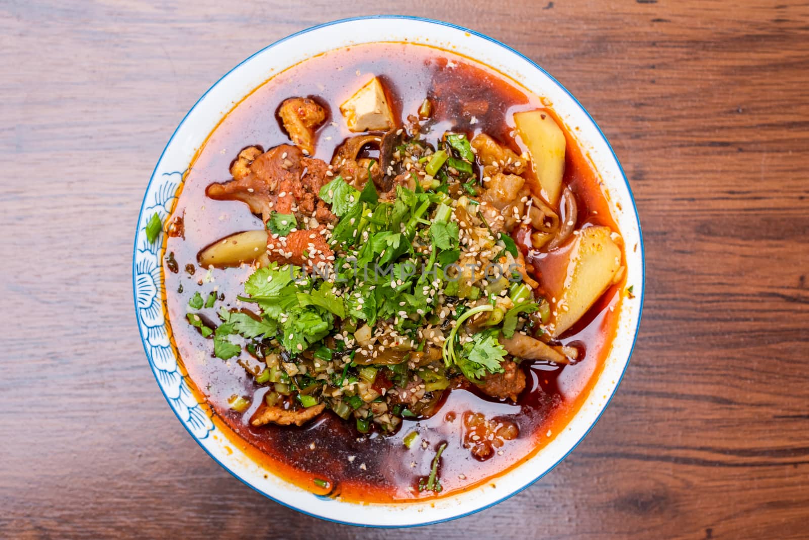 MaoCai sichuan food dish in a bowl on a table with two rice portions