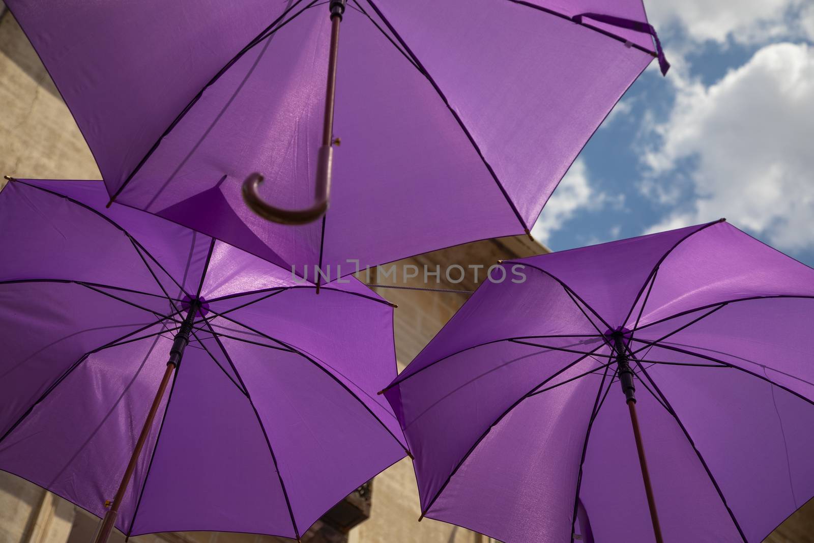 Background of purple umbrellas seen from bottom view in a small city. The very inhabitants were the one creating this art in the street during the Lavender season in a Festival in July. The Festival was held in July the 7th 2019 in a small city called Brihuega, in Guadalajara. SPAIN.