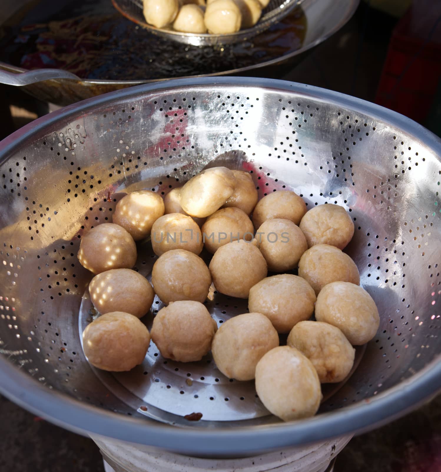 Fish balls fried in a white colander Wait for the oil to drain.