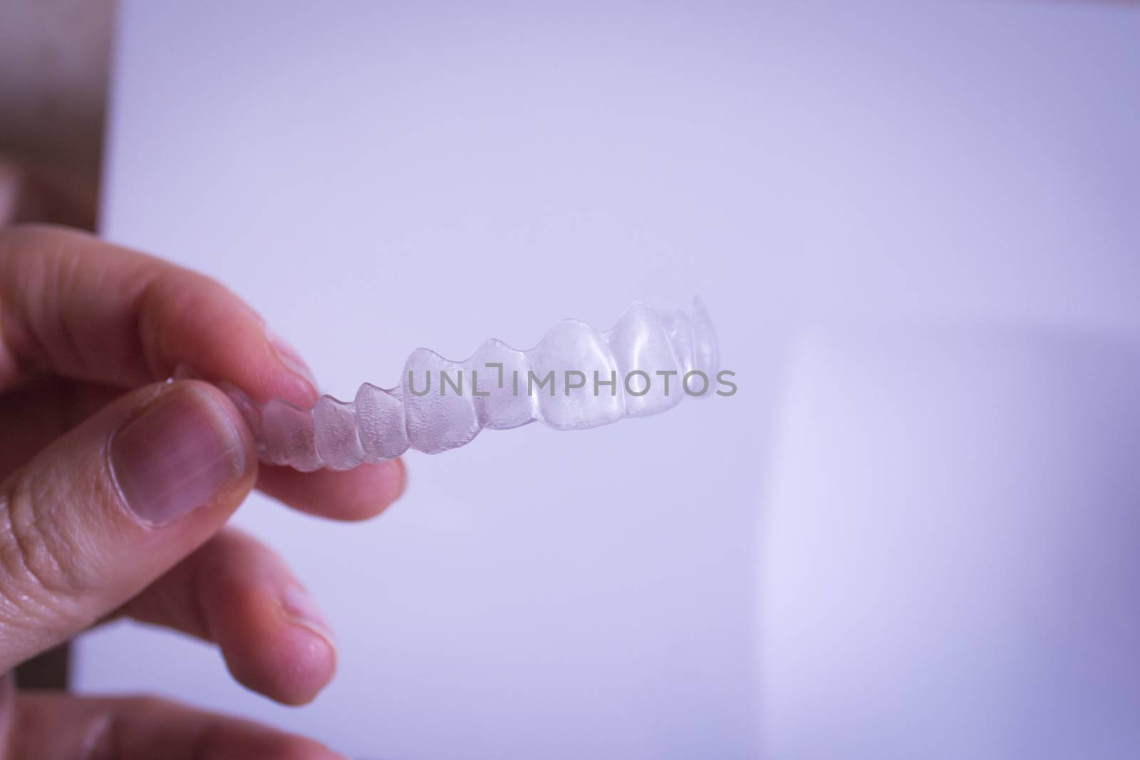 Invisible dental braces held by the hand of a woman by GemaIbarra