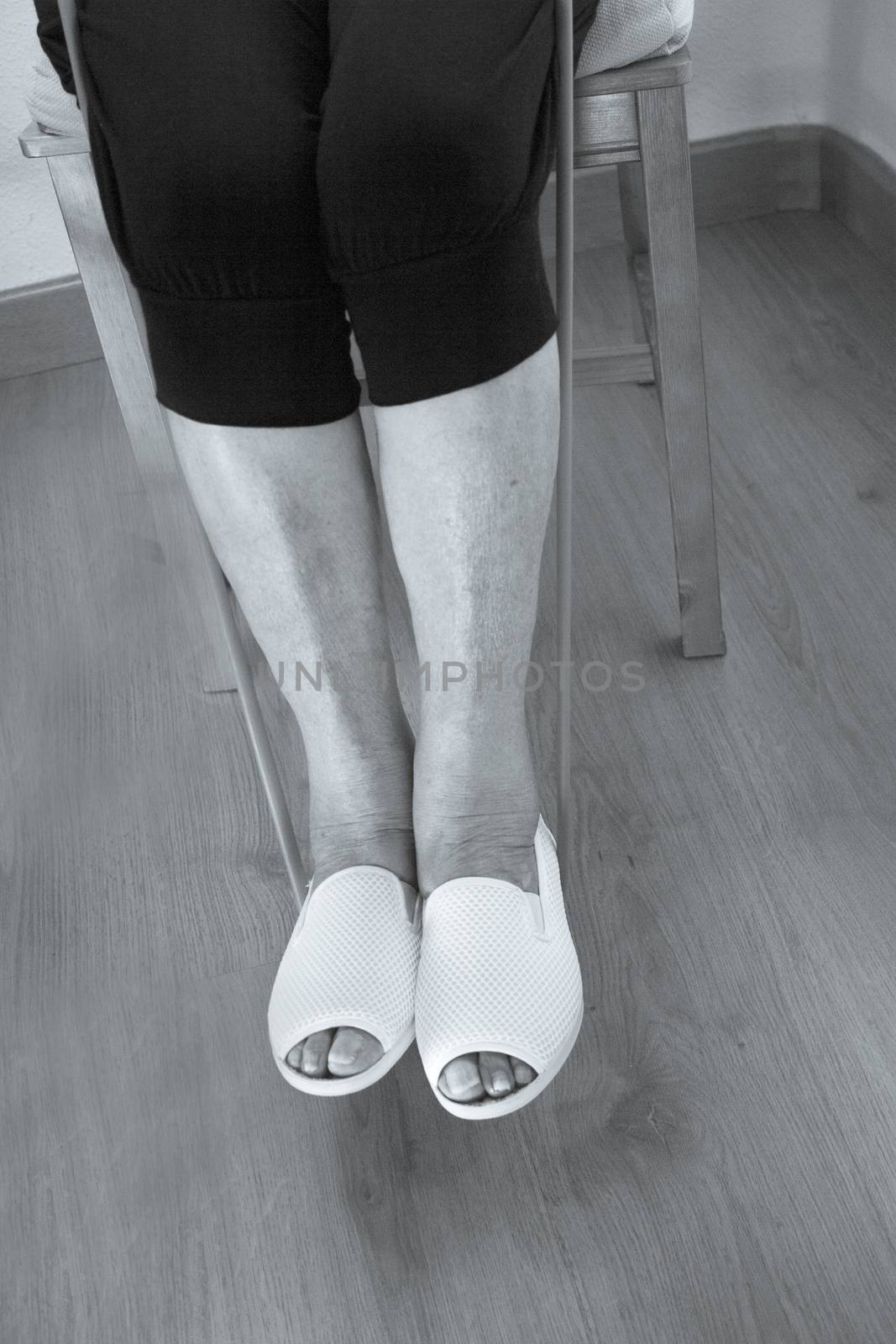 Rehabilitation exercises with elastic resistance rubber for older woman with cerebral stroke