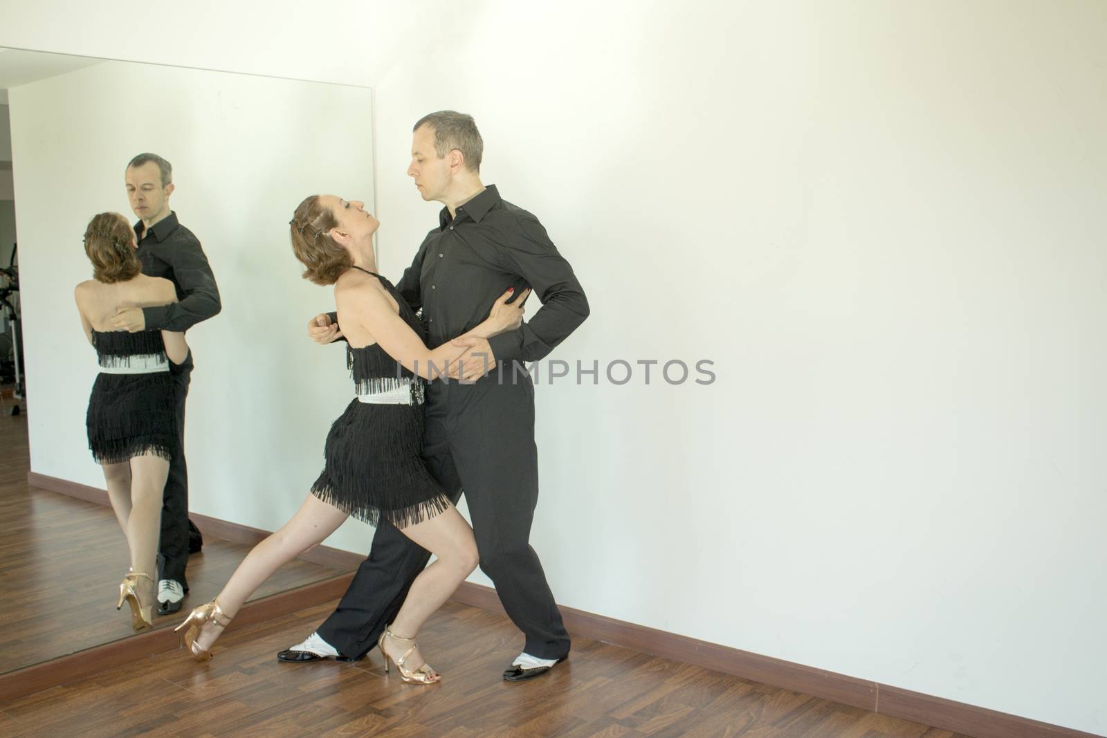 Couple of dancers with attractive latin costumes dancing salsa and different latin caribbean rhythms