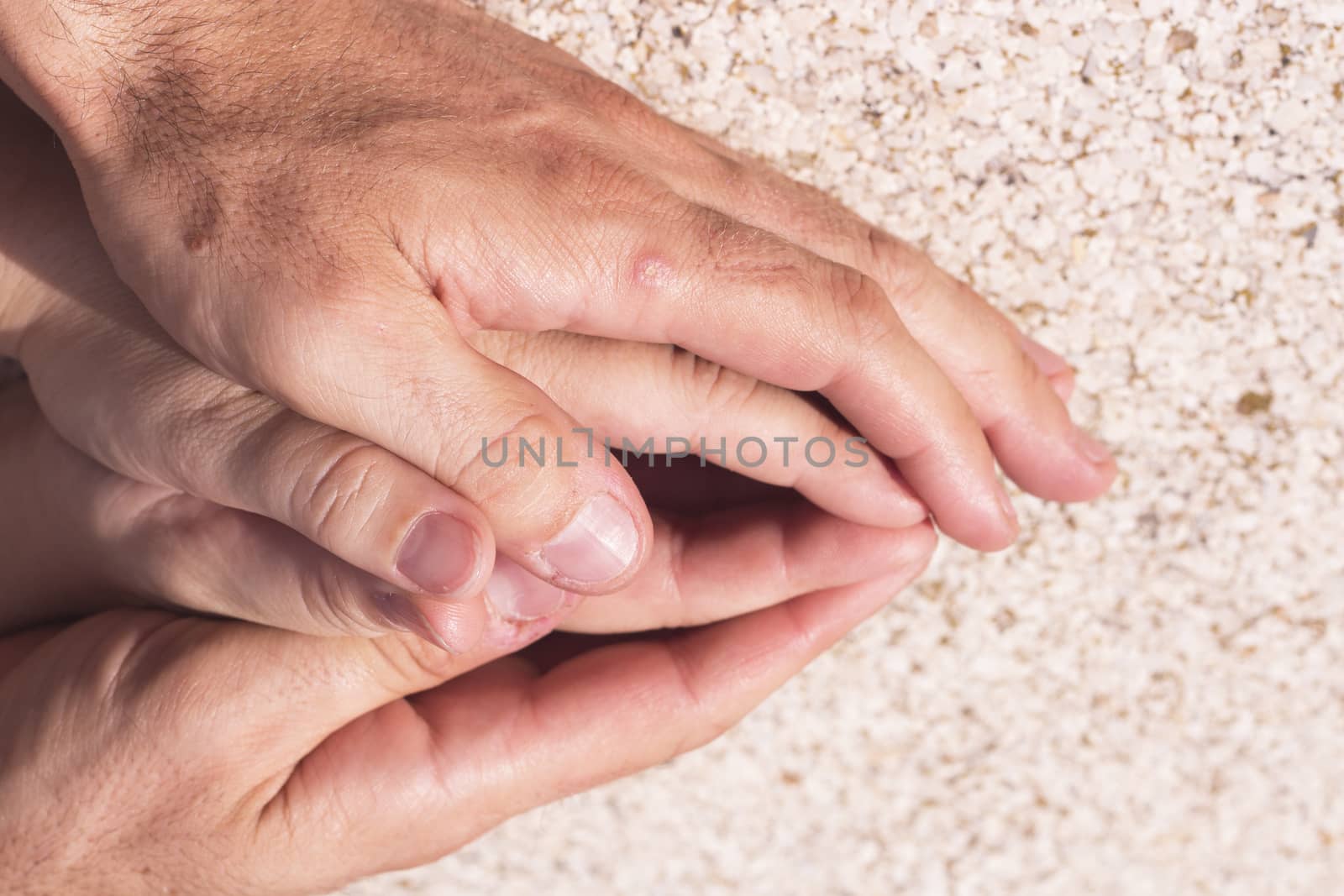 Hands of man and woman intertwined in affectionate attitude
