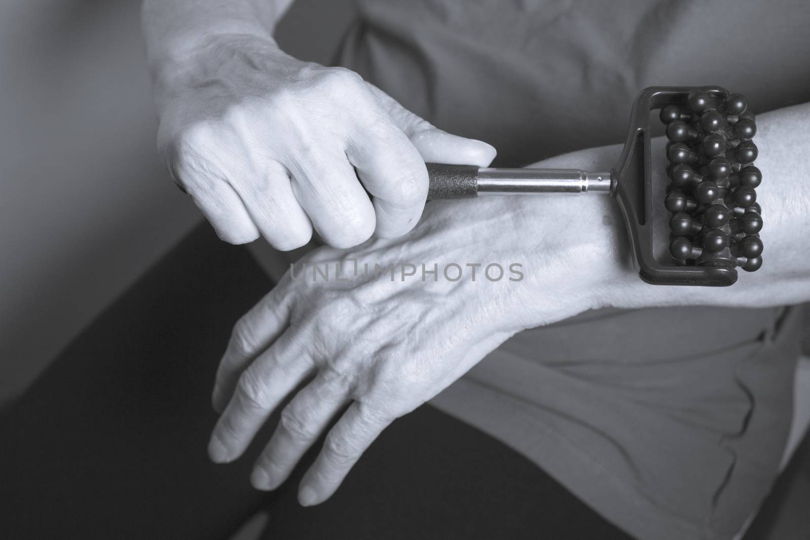 Older woman self massaging with small massager by GemaIbarra