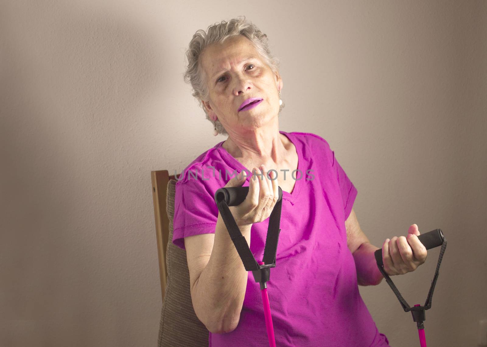 Rehabilitation exercises with elastic resistance rubber for older woman with cerebral stroke