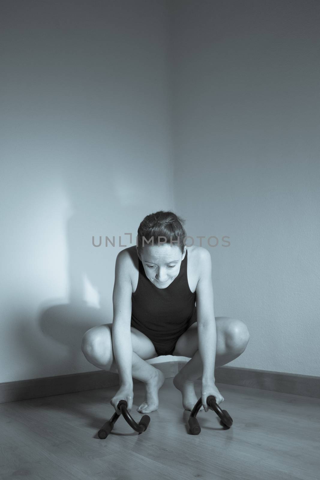 Woman initiating crow movement in yoga