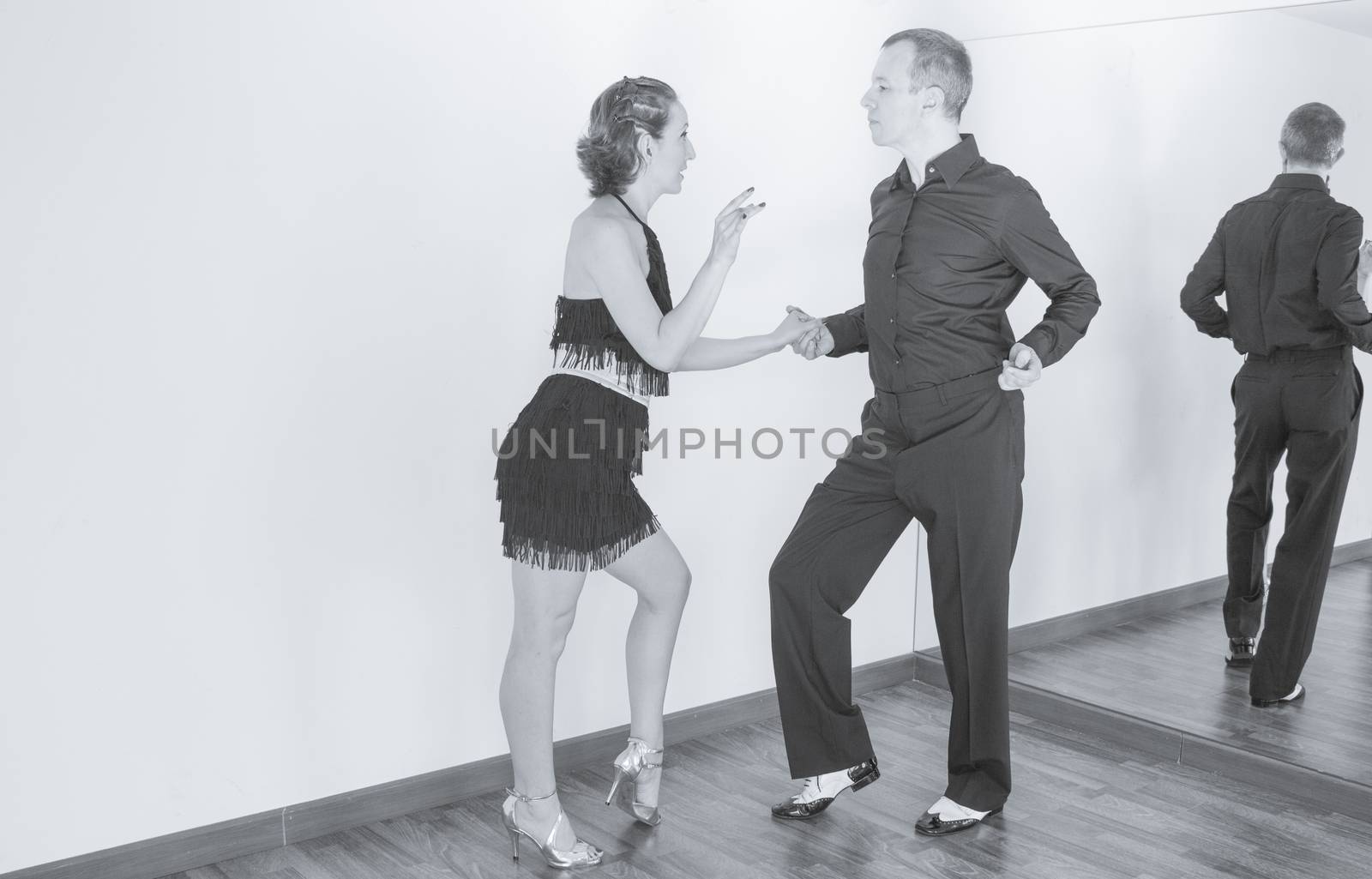 Couple of dancers with attractive latin costumes dancing salsa and different latin caribbean rhythms