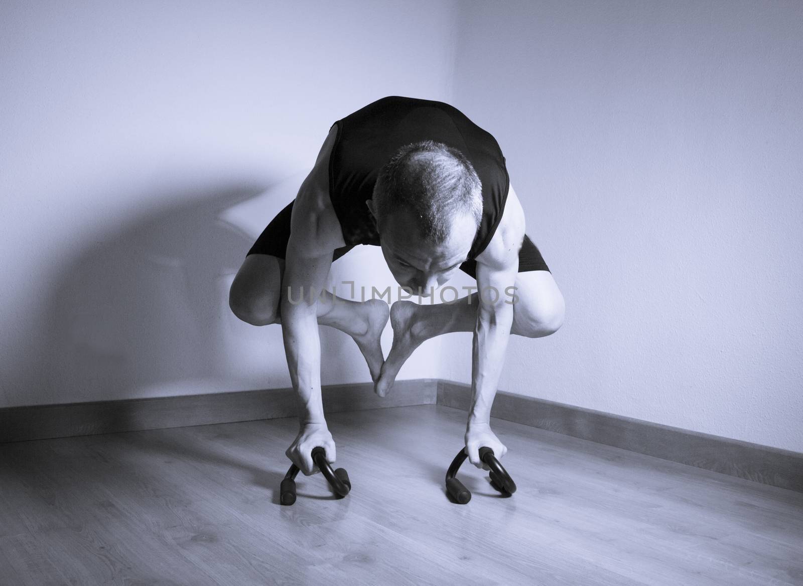 Man performing crow motion in yoga