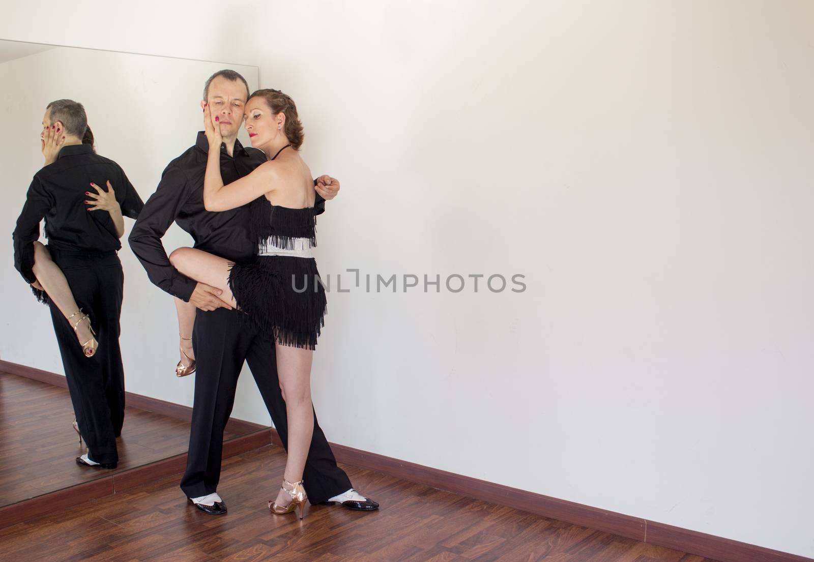 Couple of dancers with attractive latin costumes dancing salsa and different latin caribbean rhythms