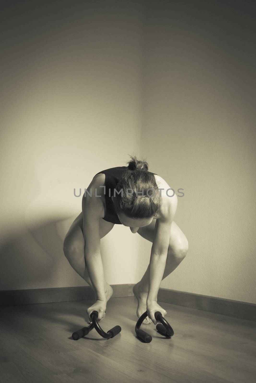 Woman initiating crow movement in yoga
