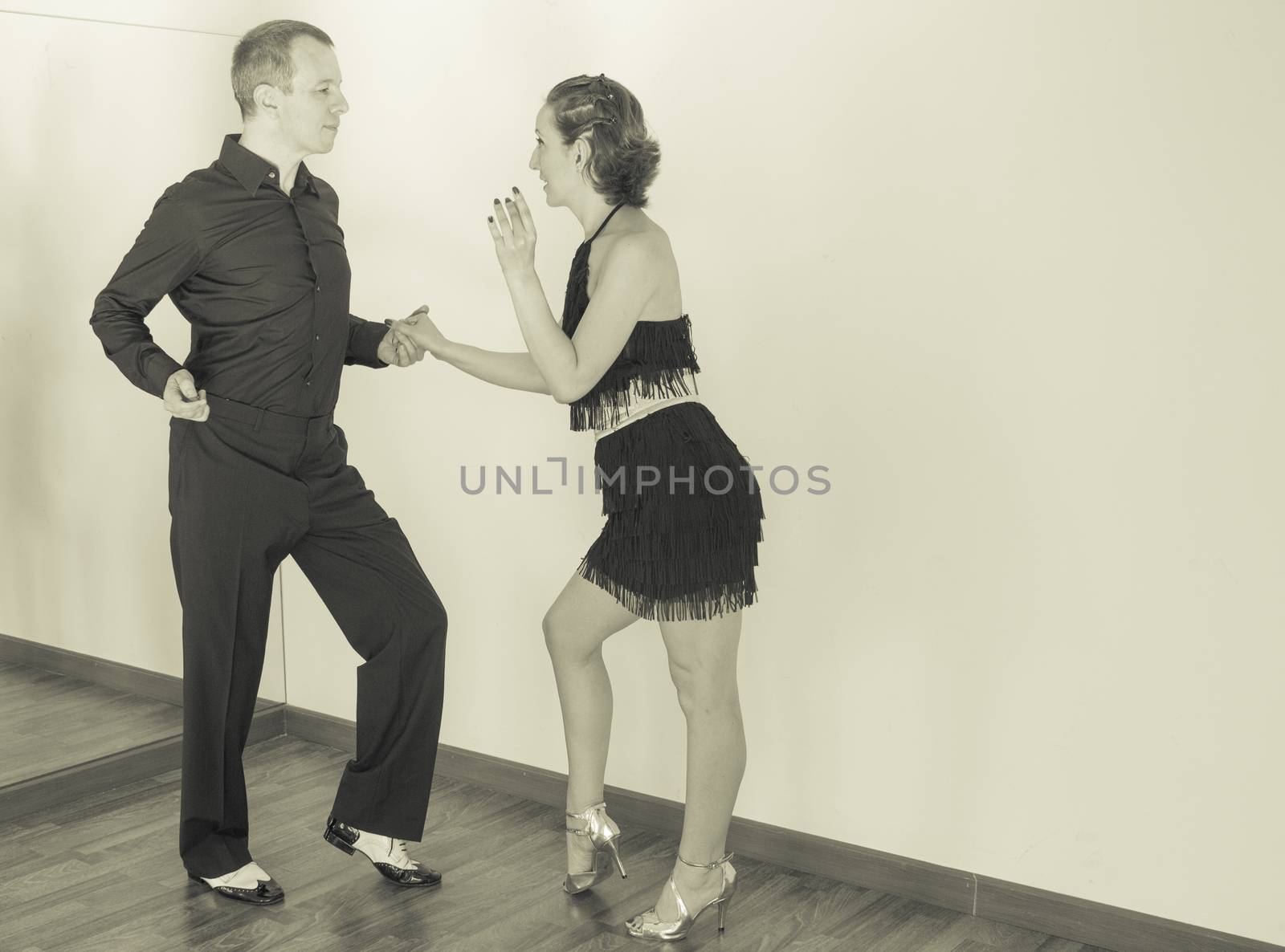 Couple of dancers with attractive latin costumes dancing salsa and different latin caribbean rhythms