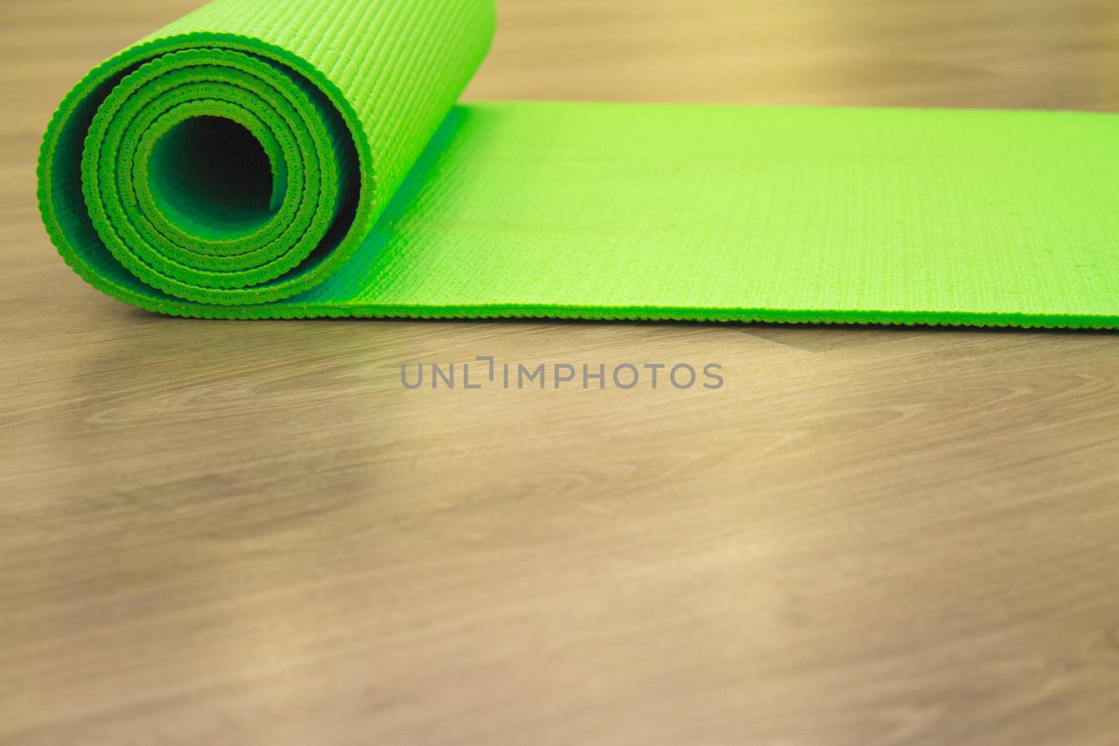 Yoga mat on wooden floor to perform meditation exercises