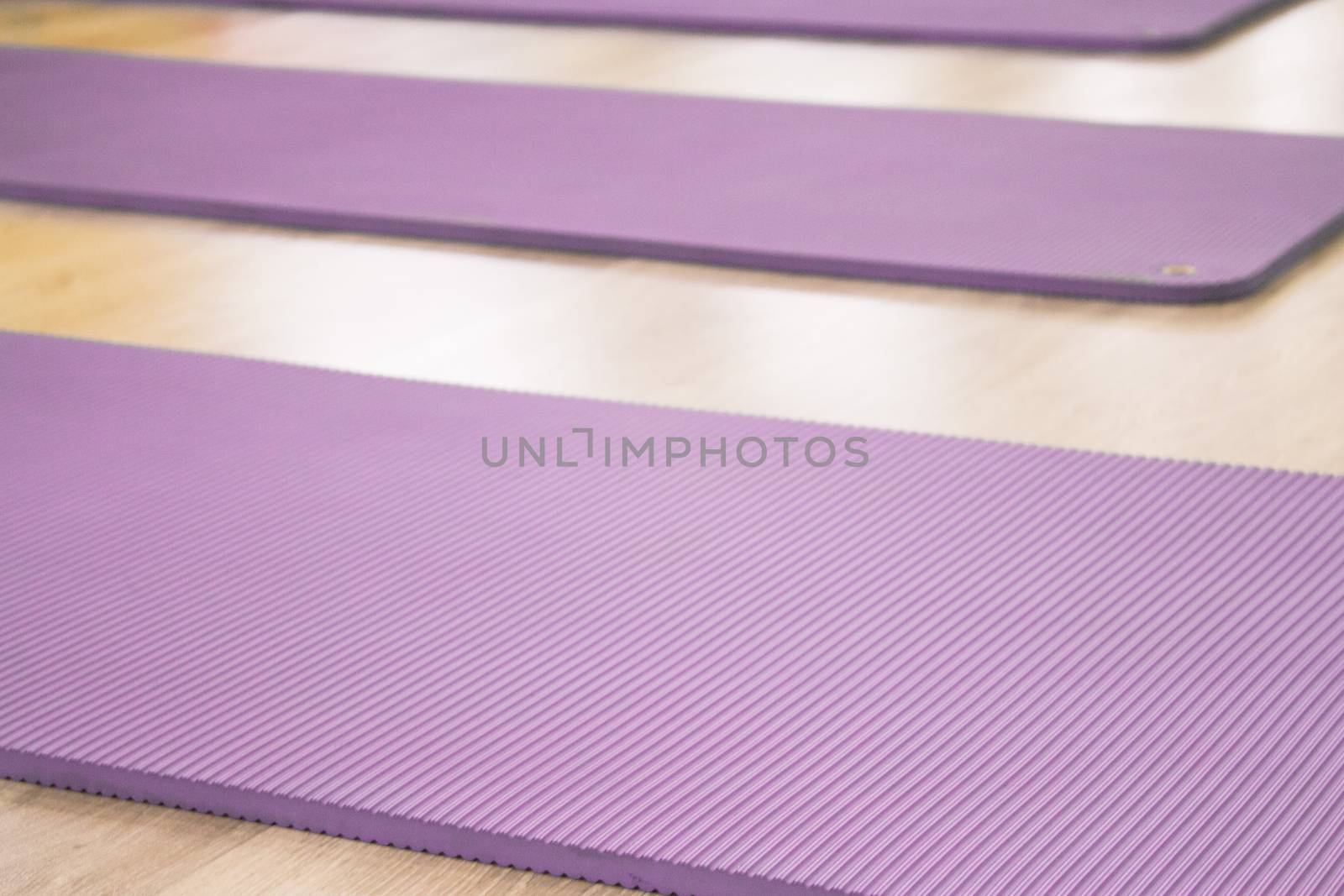 Yoga mat on wooden floor to perform meditation exercises