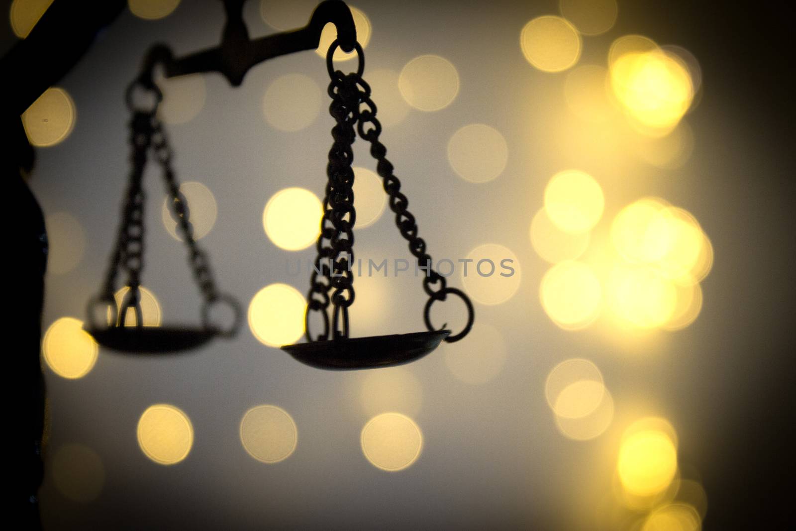 Scales of justice on bright lights background