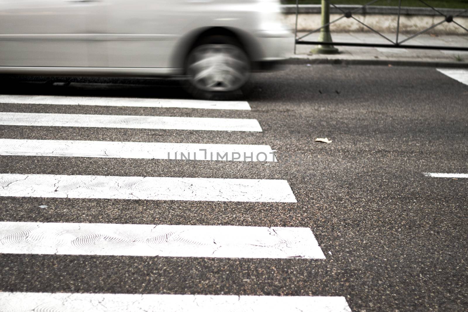Pedestrian crossing with unfocused car in the background. No people