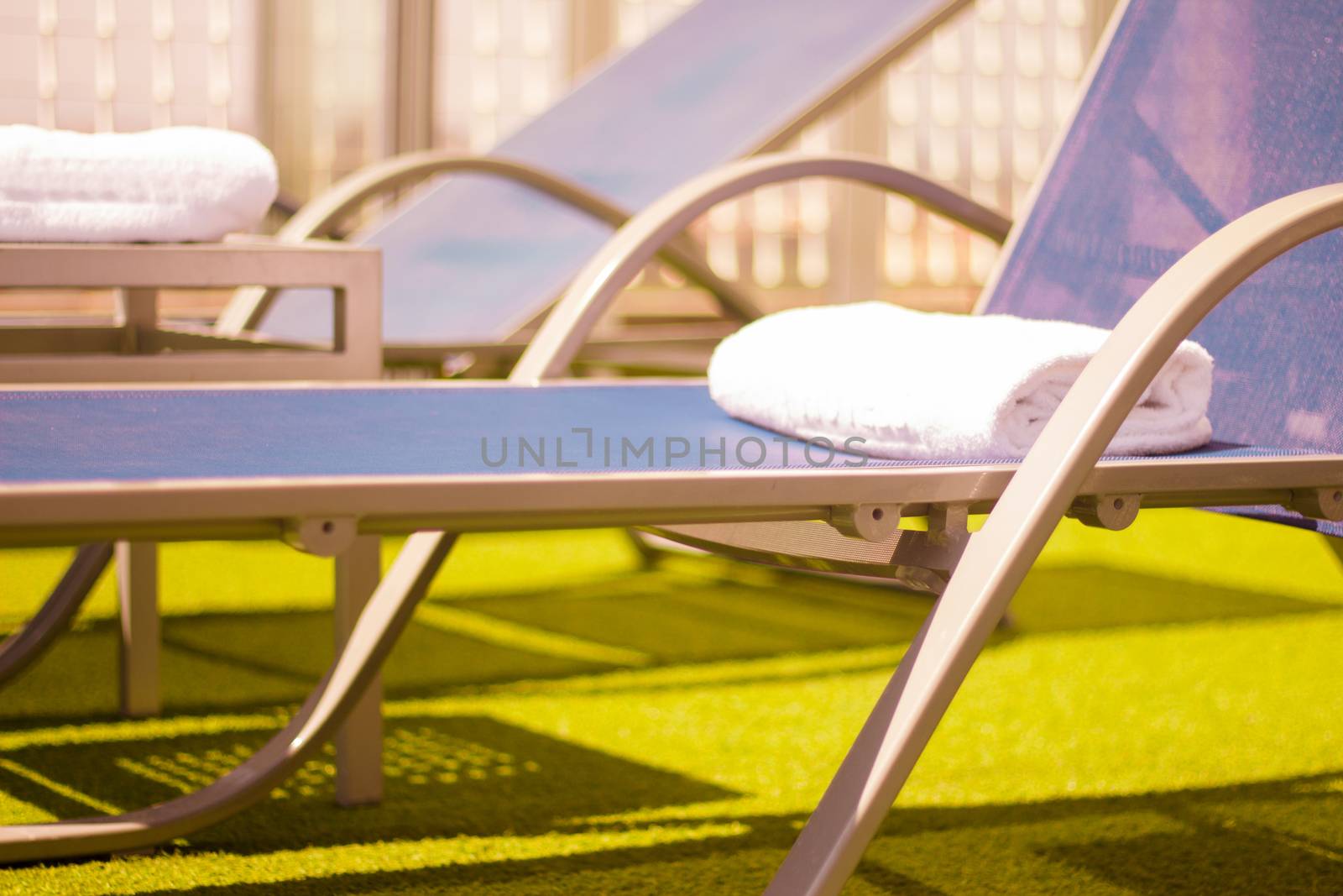 Part of pool in a hotel with sunbeds without people