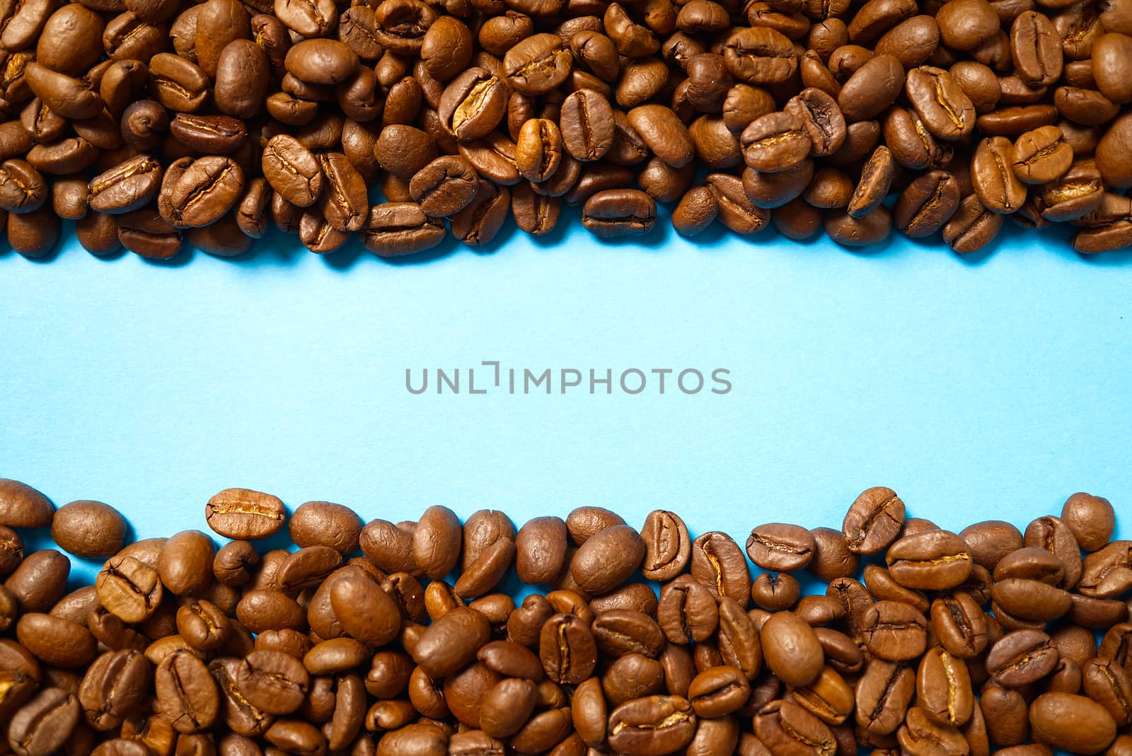 Texture of coffee beans. Roasted coffee beans background. close up Coffee beans with copy space on blue background.