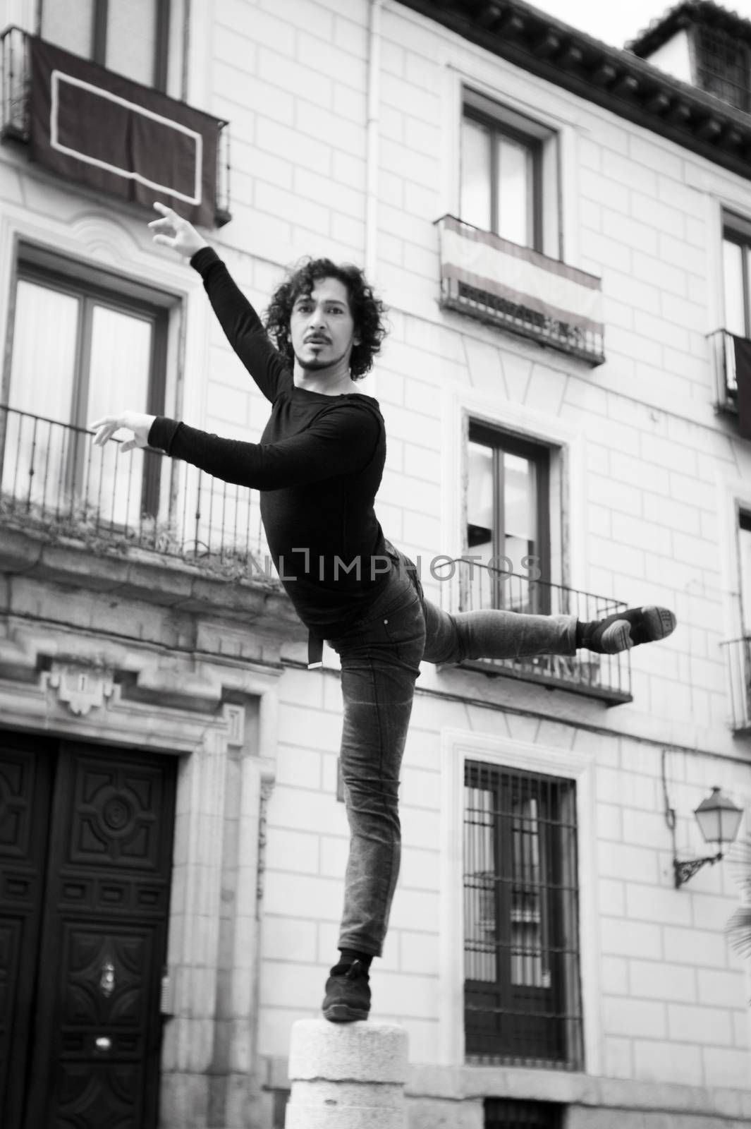 Male dancer performing pirouette. Urban background