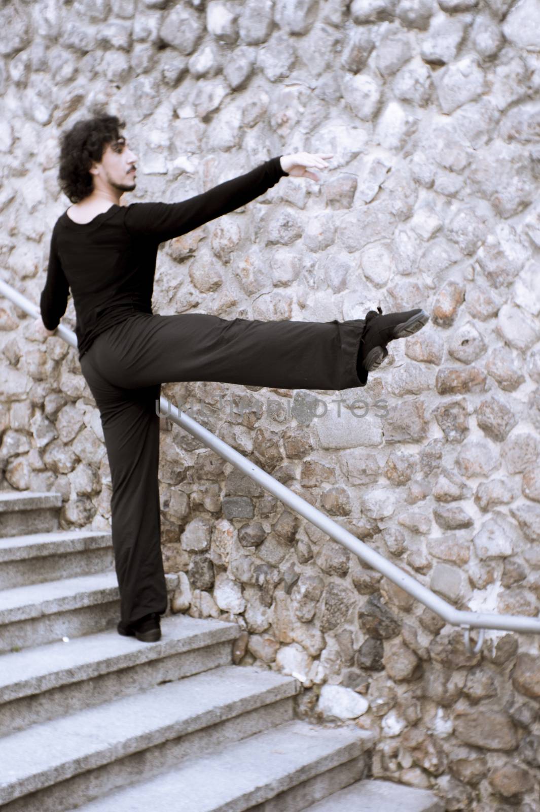 Male dancer doing a classic ballet pirouette. Urban background