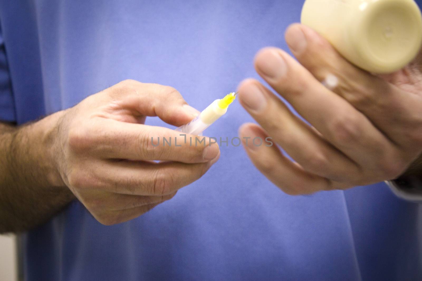 Hands of veterinarian preparing a syringe with medicine