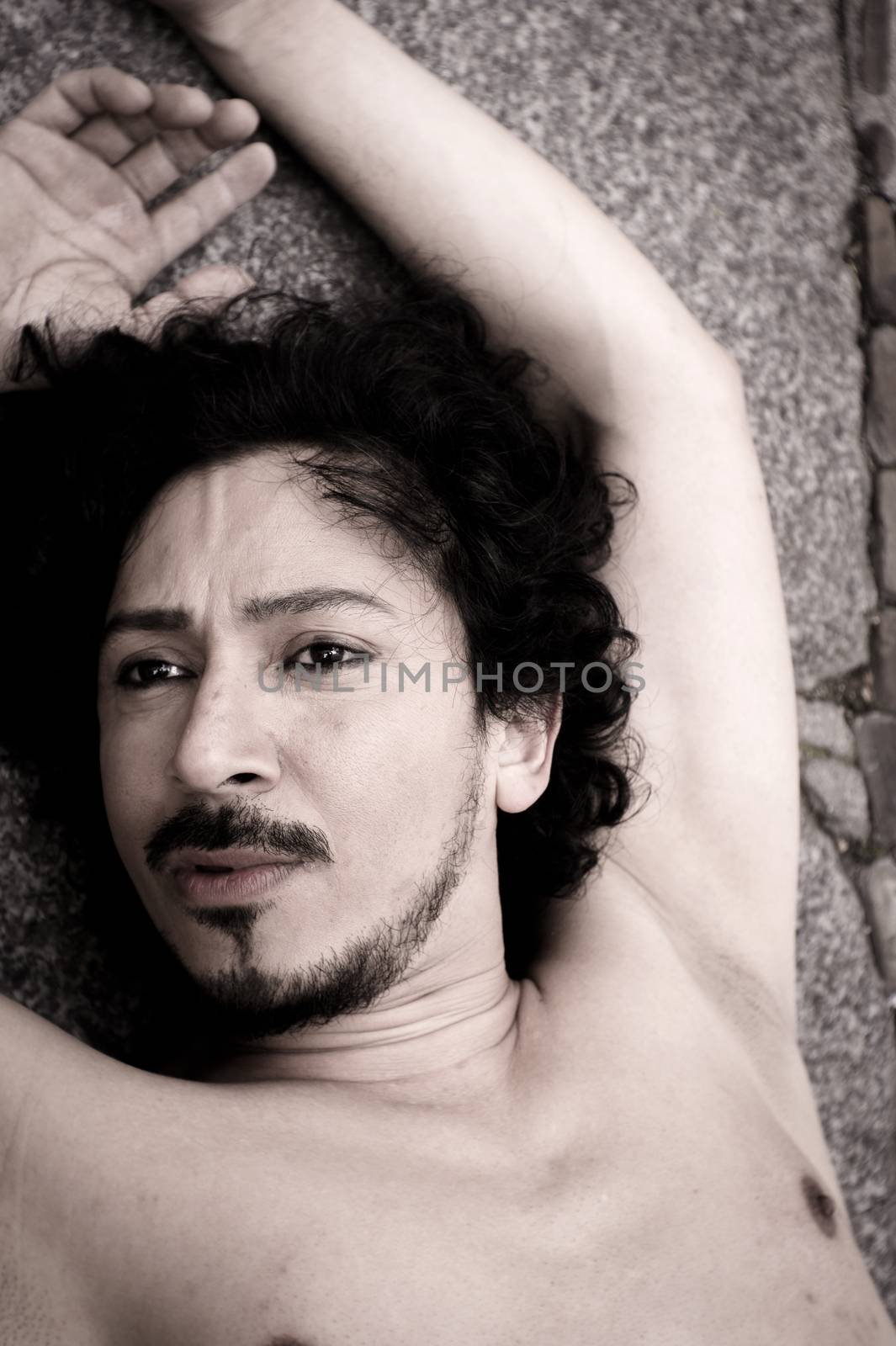 Portrait of latin man with beard and curly black hair. Naked torso