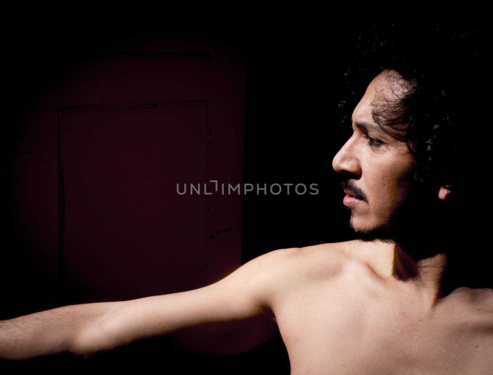 Latin male dancer posing with dancing figures. Urban background