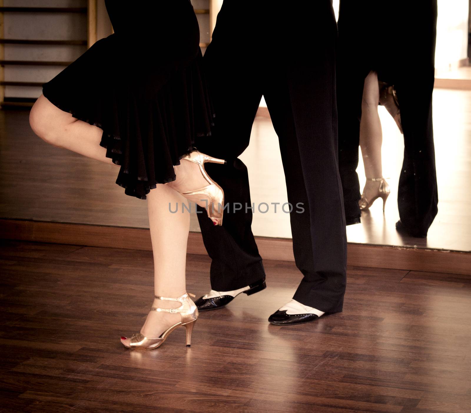 Couple of dancers dancing lindy hop in bright gold and black and white shoes

