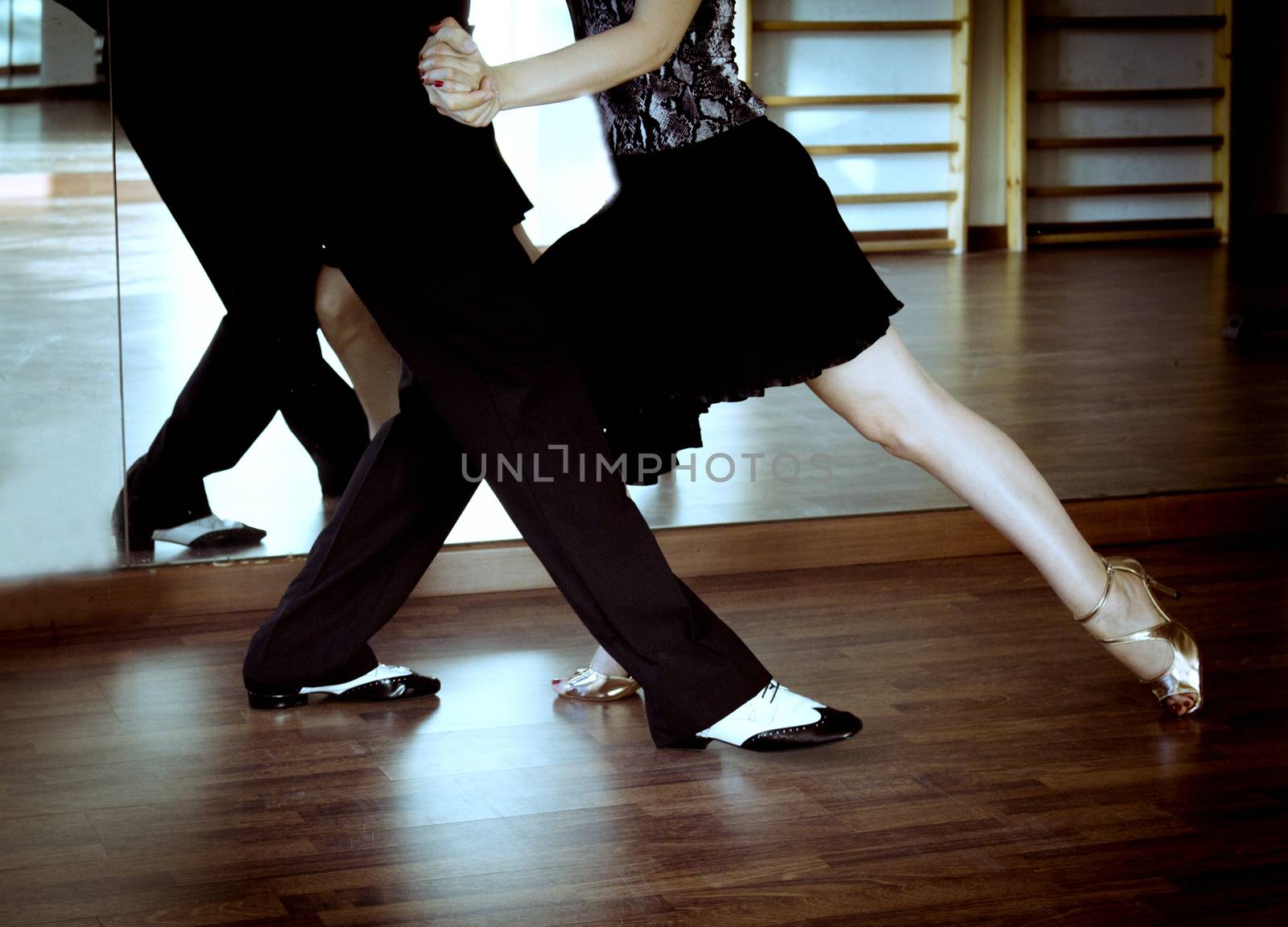 Couple of dancers dancing lindy hop in bright gold and black and white shoes
