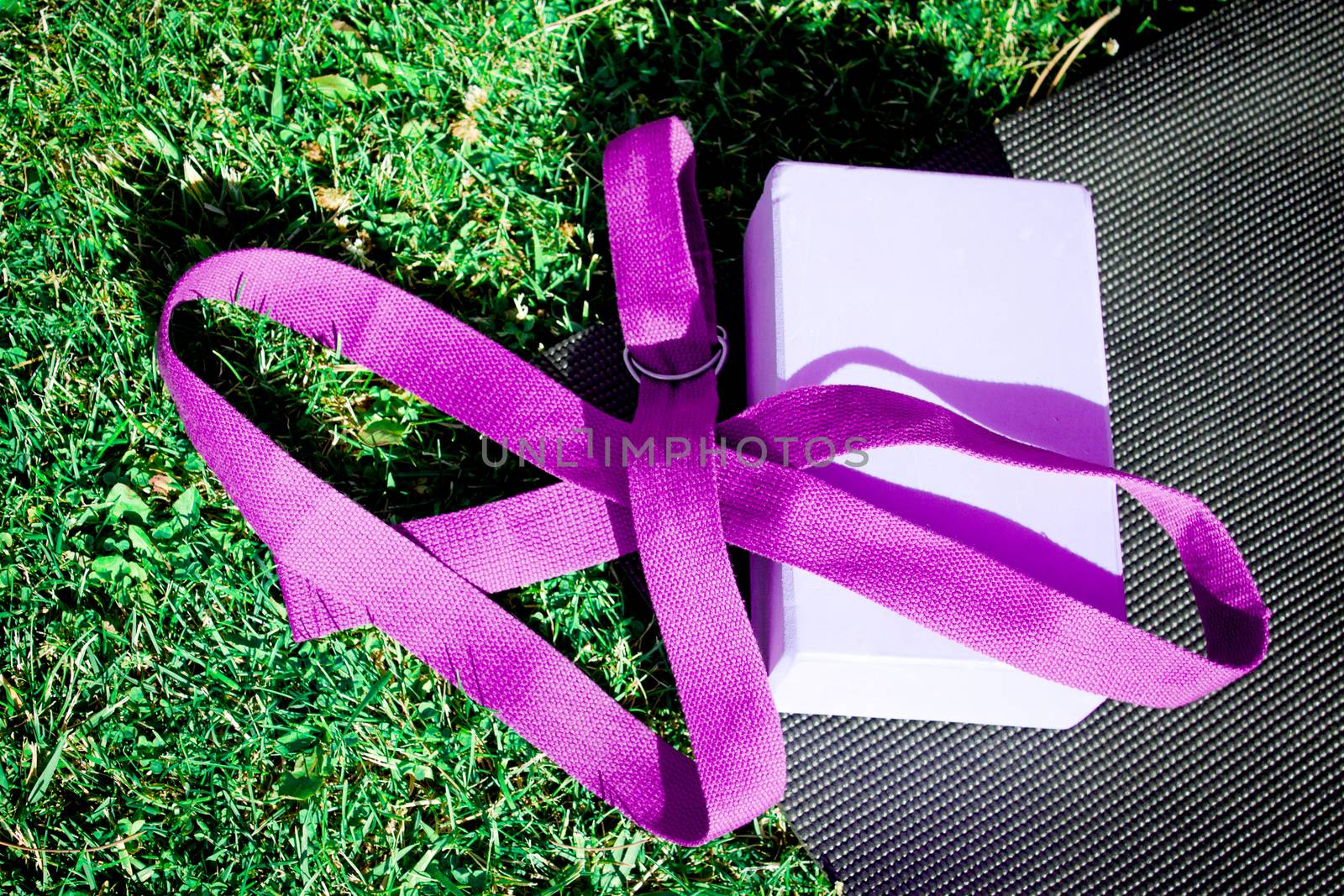 Yoga mat on the grass with yoga block. No people