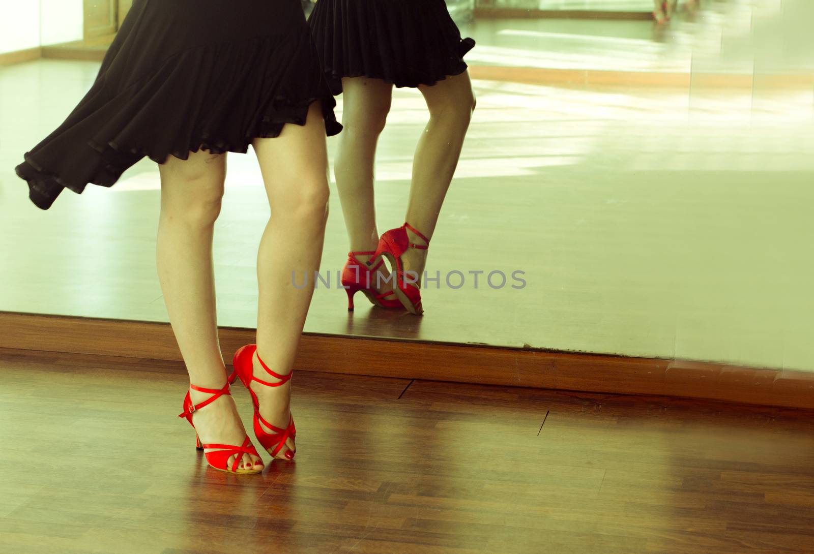 Legs of girl with red shoes dancing