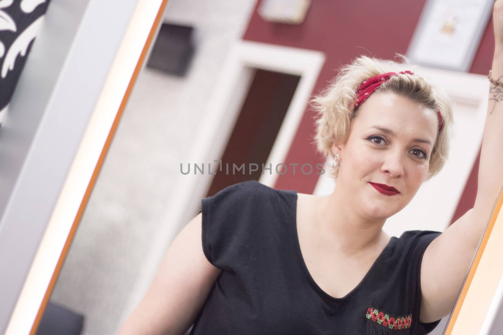 Portrait of blonde woman with short hair and pinup style. Relaxed expression