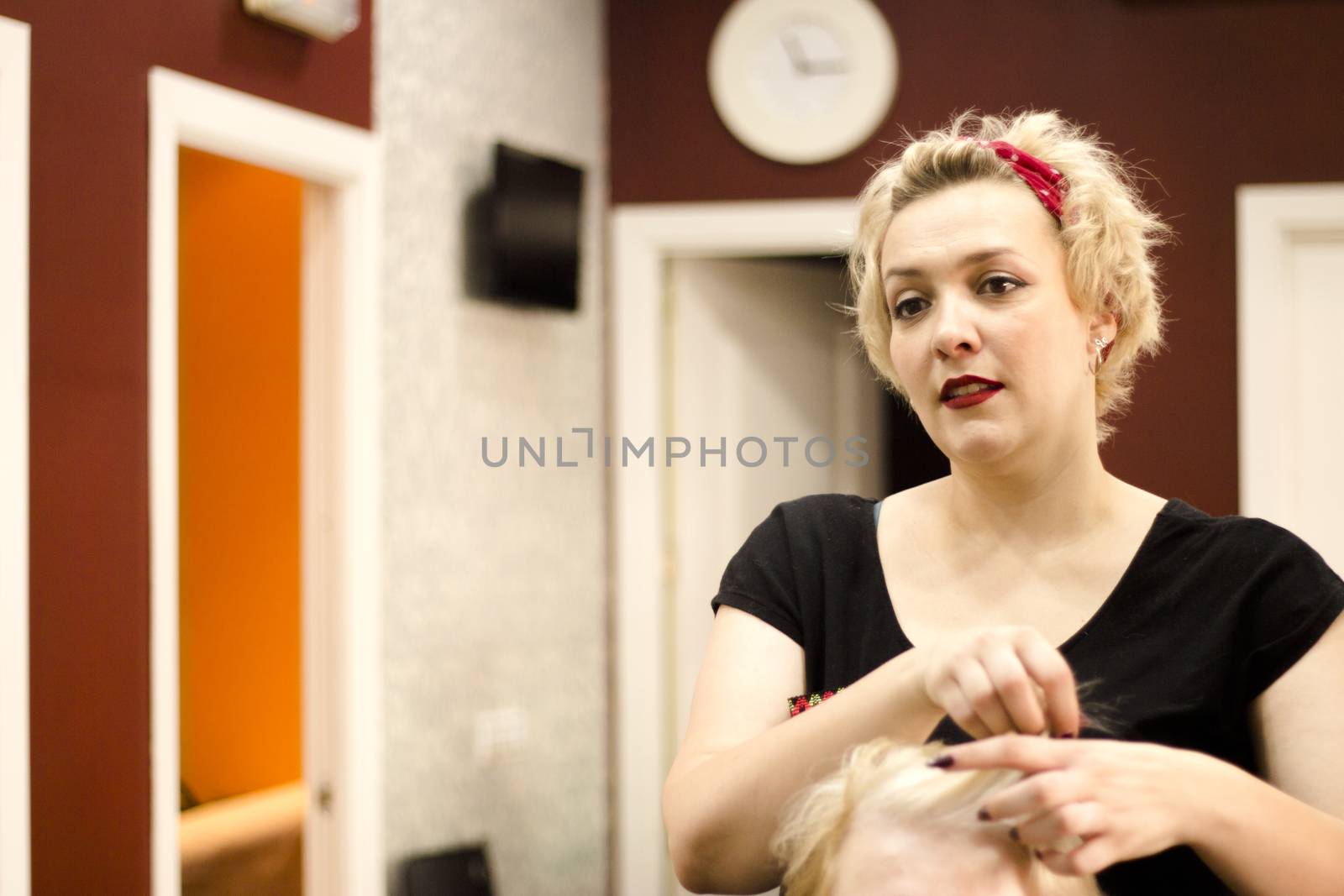 Hairdresser in positive attitude brushing the hair of a client