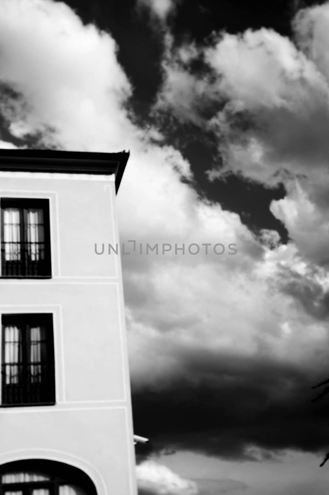 Sky in black and white with part of building. Dark scene and feeling sad