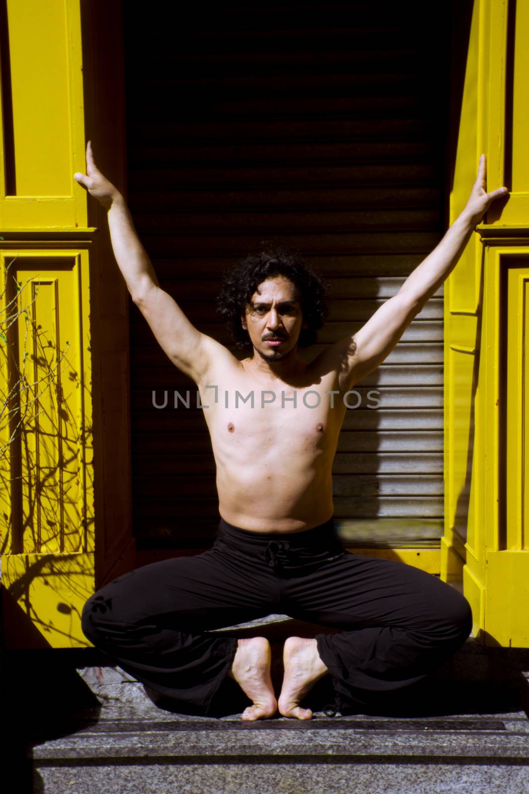 Latin male dancer posing with dancing figures. Urban background