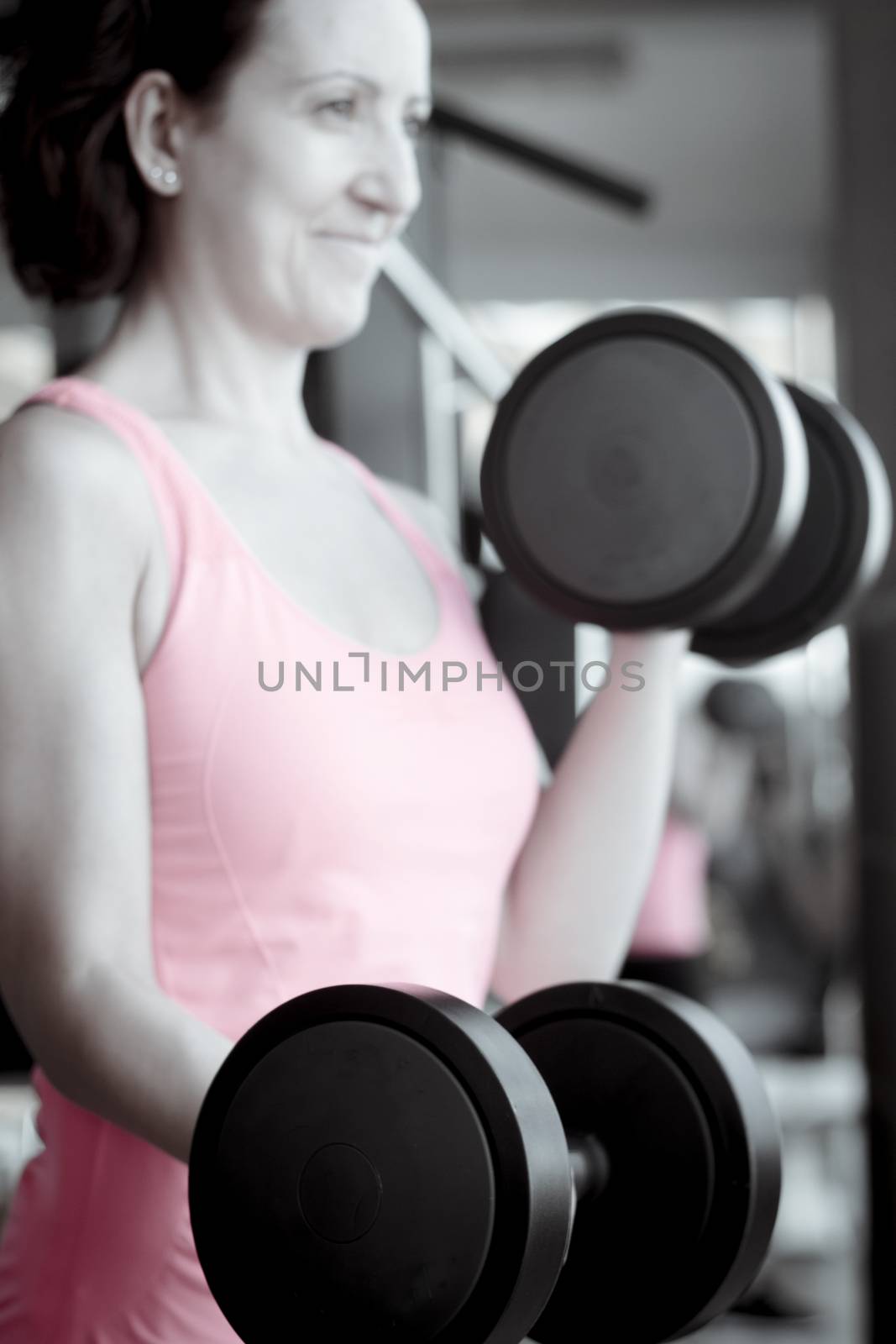 Girl doing exercise with 4 kg weights in the gym