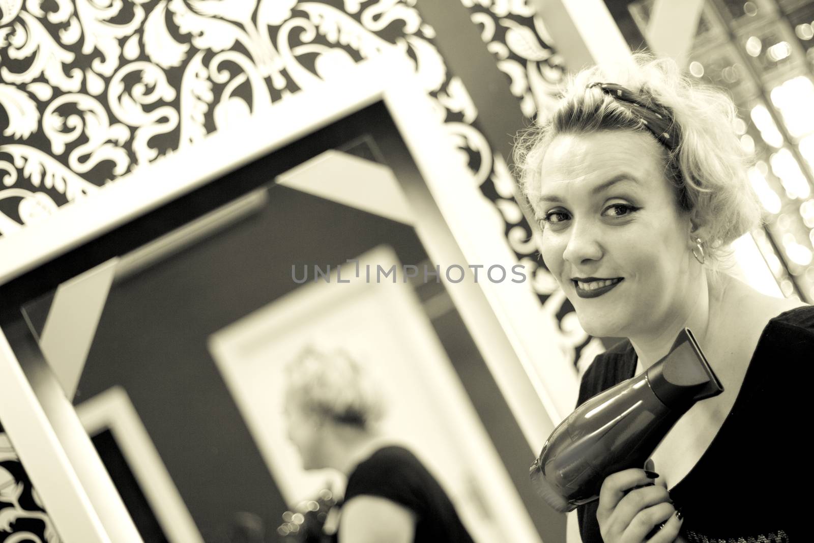 Hairdresser drying hair with red hand dryer