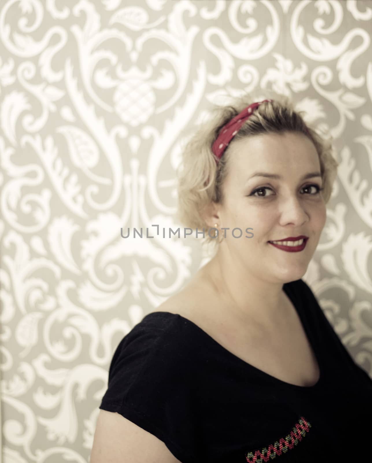 Portrait of blonde woman with short hair and pinup style. Relaxed expression