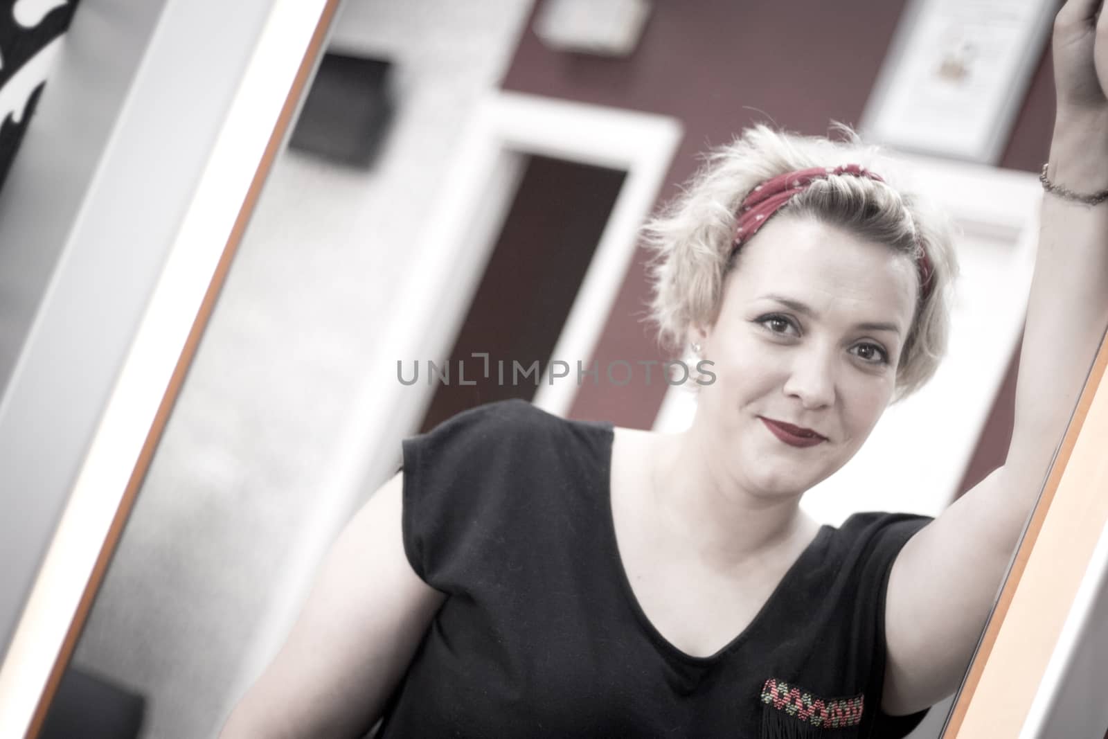 Portrait of blonde woman with short hair and pinup style. Relaxed expression