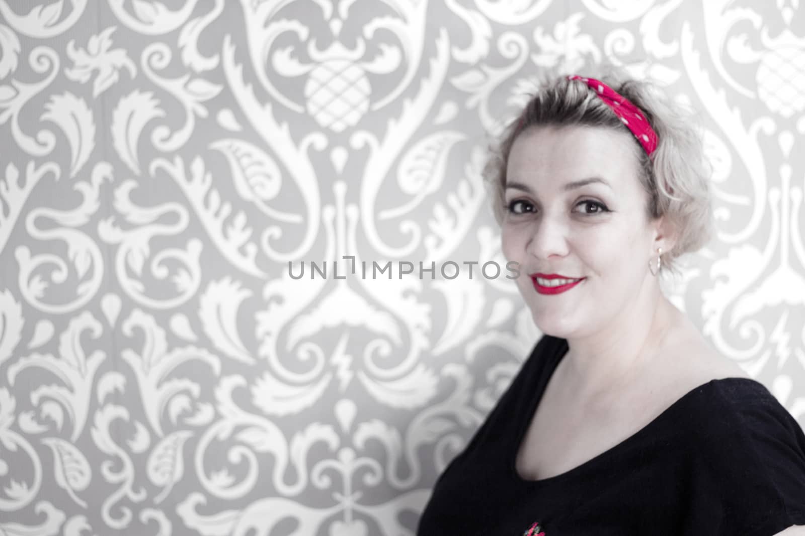 Portrait of blonde woman with short hair and pinup style. Relaxed expression