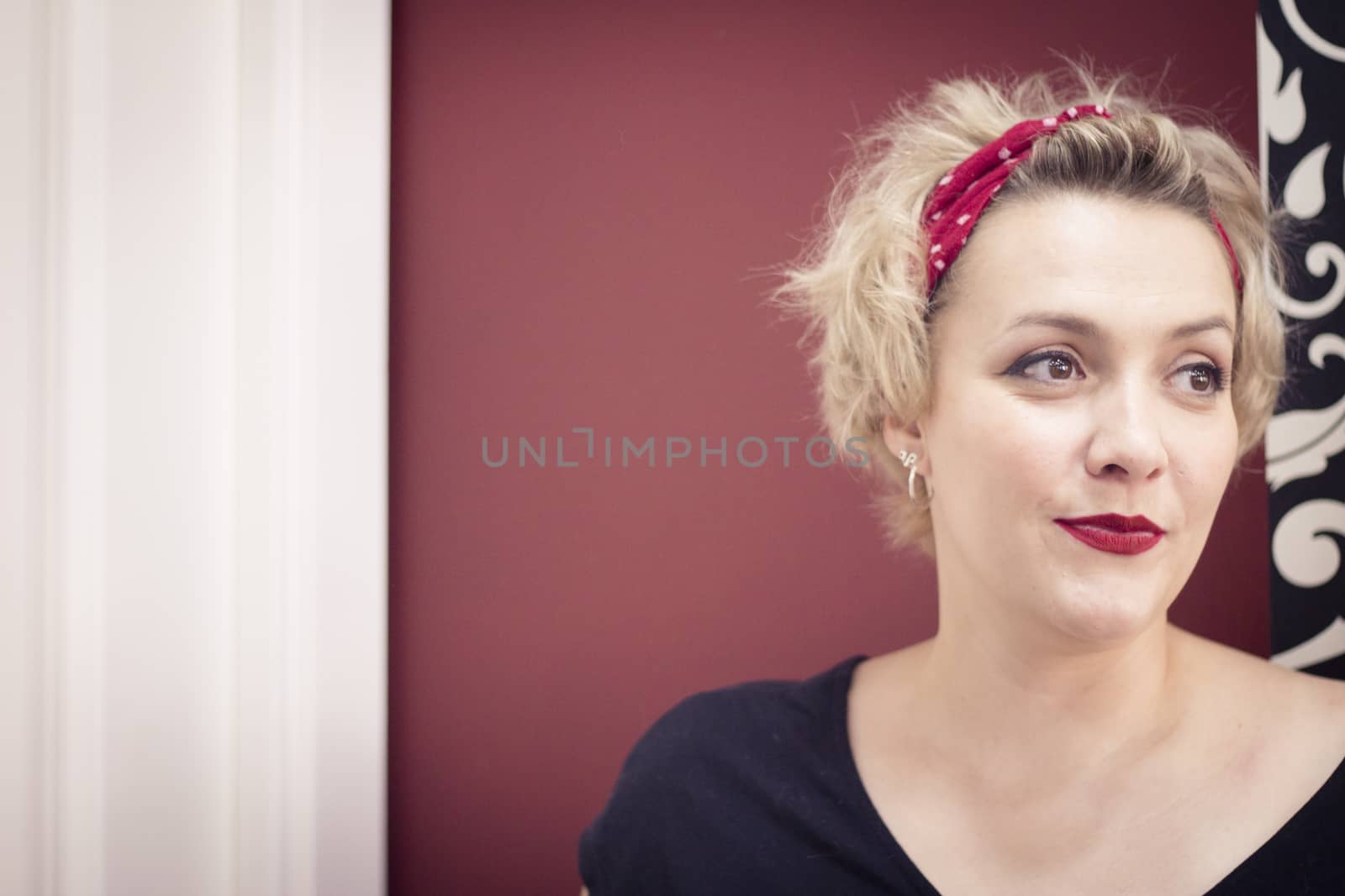 Portrait of blonde woman with short hair and pinup style. Relaxed expression
